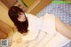 A woman laying on top of a bed in a white shirt.
