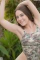 A woman in a camo bodysuit posing for a picture.