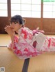 A woman in a pink kimono laying on the floor.