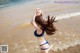 A woman in a blue bikini standing in the water.