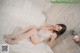 A woman laying on a bed in a white lingerie.