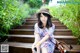 A woman sitting on a wooden bench wearing a hat.