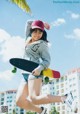 A young woman is jumping in the air with a skateboard.