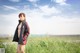 A woman in a black jacket standing in a field.